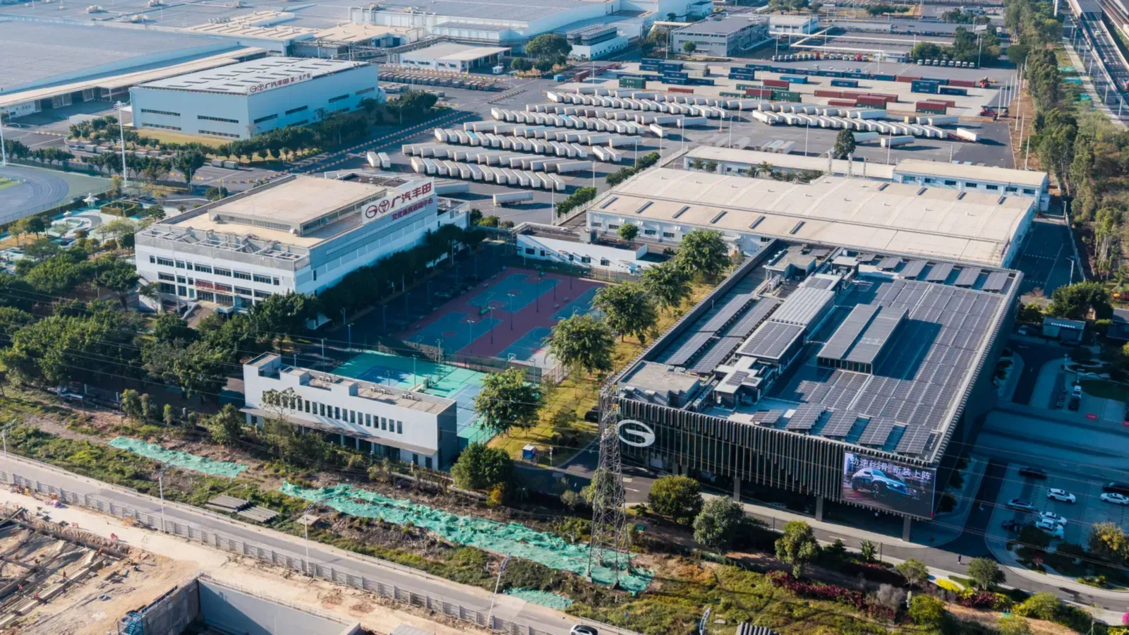 Vista aérea de la sede de GAC Toyota en Guangzhou, con su edificio de oficinas y el patio de vehículos terminados